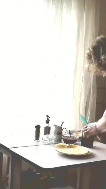 Iconic moment from "Adult woman blonde in transparent negligee and beautiful cute brunette naked girl cooks in kitchen."