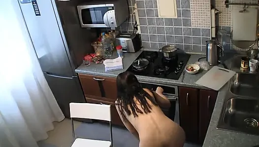 Çıplak orta yaşlı seksi kadın mutfakta bir şeyler pişiriyor