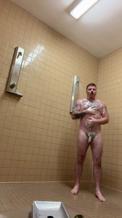 Необрезанный татуированная Jock принимает душ после спортзала
