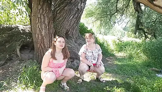 Zwei frauen, mädchen und reife milf zogen rotes höschen aus, pinkeln am straßenrand in der Öffentlichkeit, pinkeln im freien, lesben küssen