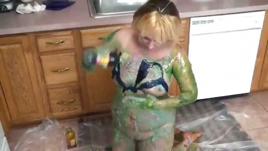 Blonda în bucătărie freacă vopsea verde peste țâțe și cur