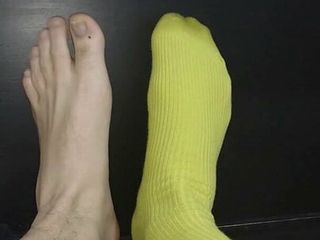Groene kousen aan de ene voet en de andere op blote voeten