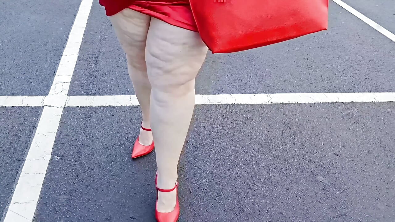 Smuk kvinde, der går udendørs på parkeringspladsen, viser sig frem for fremmede