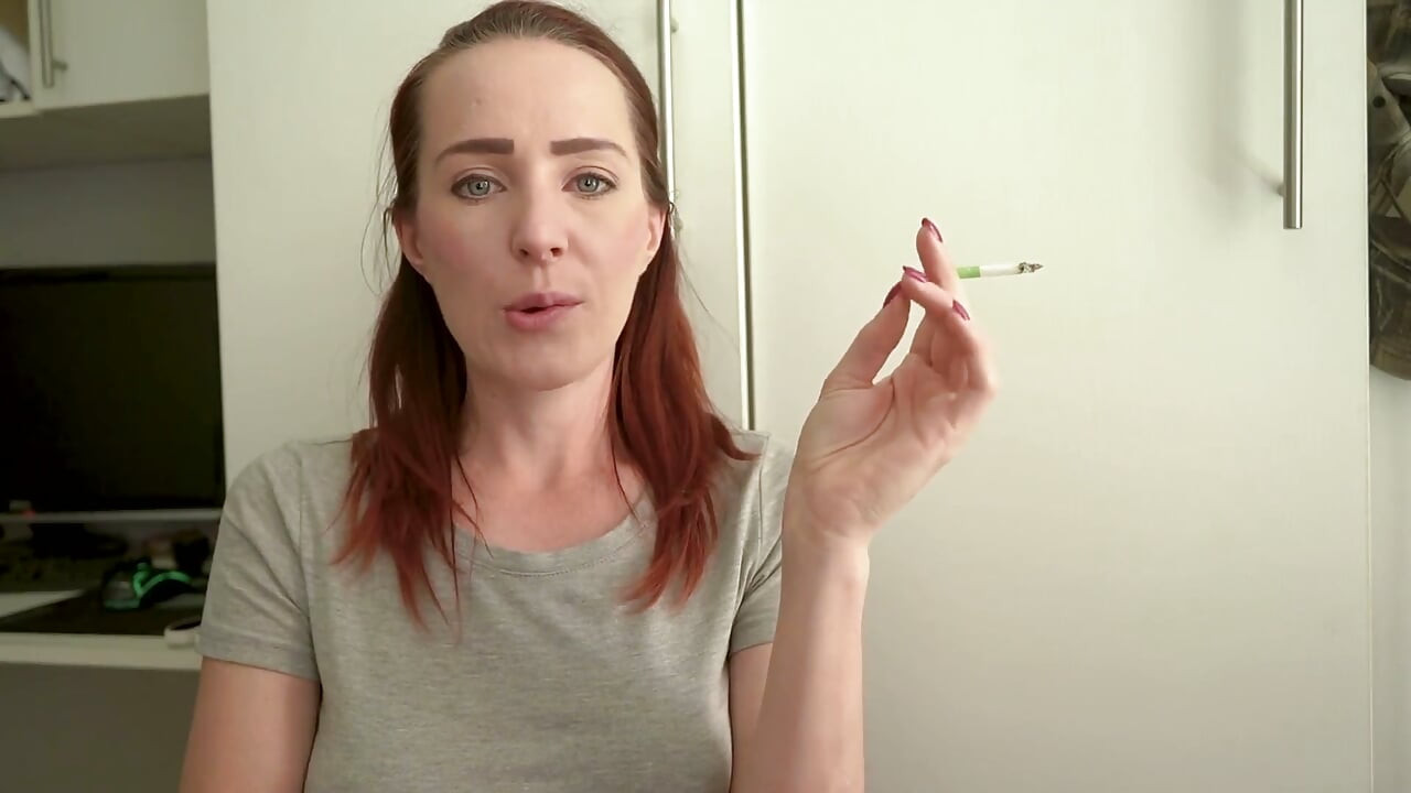 Schattige brunette die in een strak topje rookt