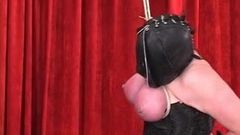 Corseted shackled woman in leather hood gets tits bound so they become red