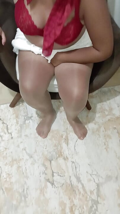विधवा औरत जो हेडस्कार्फ, स्कर्ट और शीयर स्टॉकिंग्स पहने हुए खुद को उंगली कर रही है।