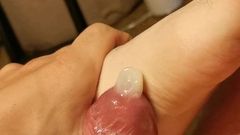 Sloppy one hand Footjob with a condom