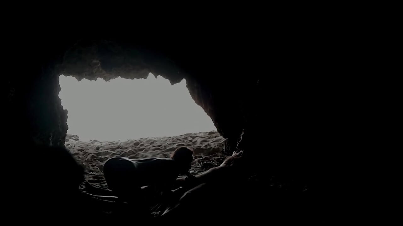 Pareja grabada en la playa, dentro de la cueva