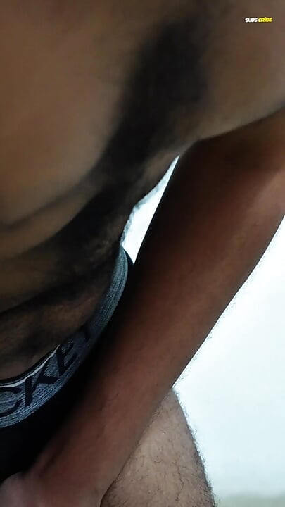 Young man wearing black underwear is dancing cock while holding his groin area.