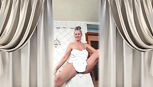 Die Attraktive Hausfrau Lukeria Flirtet in Der Küche in Einem Weißen Stringtanga Und Einer Kleinen Schürze.