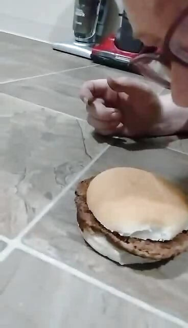 Gorda grandota piggy comiendo hamburguesa del piso manos libres