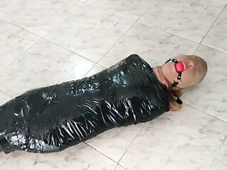 Klebeband mumifiziertes Mädchen in Strumpfhosen mit Kapuze und mit Ball geknebelt