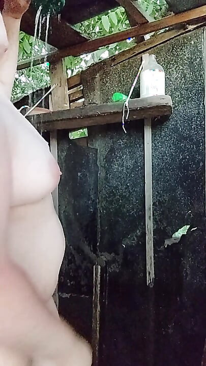 I'm watching a curvy girl wash herself in the street.