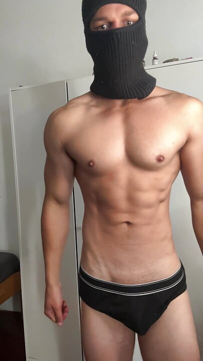 Masked young hunk showing off his muscles