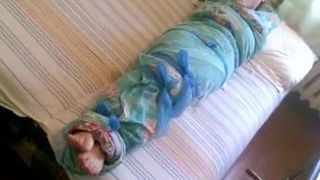 Menina descalça mumificada em um lençol