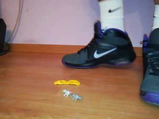 Giocattolo che calpesta schiacciamento in calzini bianchi e scarpe da ginnastica Nike