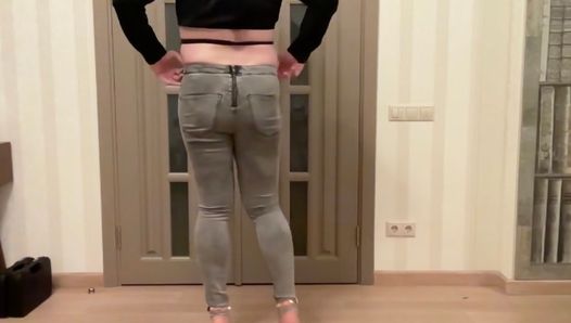 Femboy en jeans ajustados grises con cremallera en la espalda, tacones altos y blusa negra recortada bailando masturbándose y corriéndose