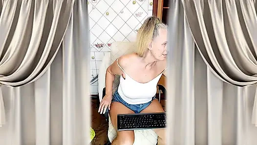 Cheerful housewife Lukerya flirts in the kitchen in tight denim shorts.