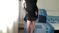 Transexual milf cachonda muestra su cuerpo con un vestido de satén negro, piernas delgadas desnudas, tanga y tacones rojos