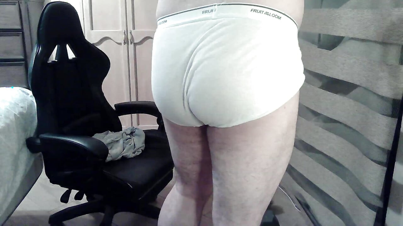 Muscular camboy flexes his muscles and squats