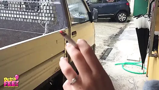 Çarpıcı esmerden açık havada sigara içiyor