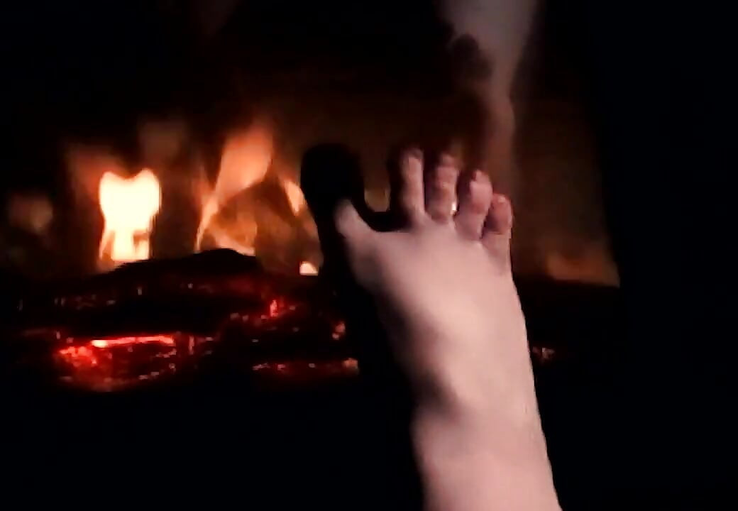 Aquecendo meus pés no fogo para que eles se aqueçam e suassem para seu pau e bolas