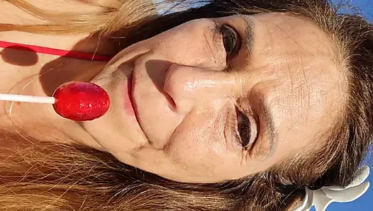 Melissa johnson lutscht und leckt einen kirschenlutscher am .beach