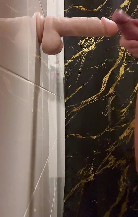 Suger en stor dildokuk i badrummet