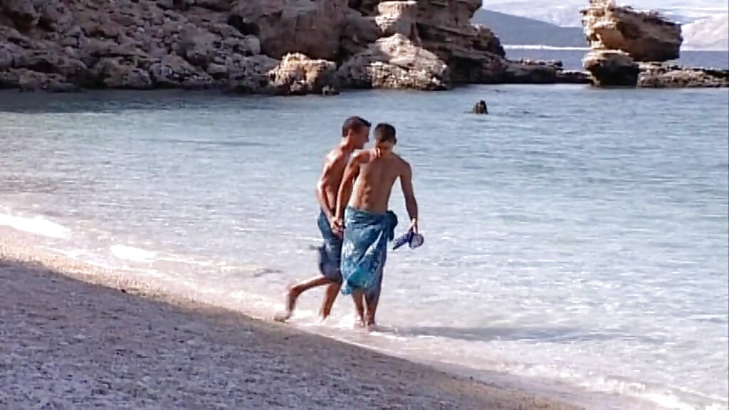 Νεαρό δίδυμο κρεμασμένων μυών κατεβαίνει μαζί στην άμμο και