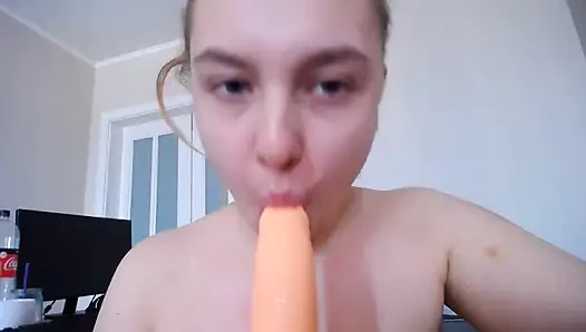 Девушка плюет на сиськи и сосет дилдо