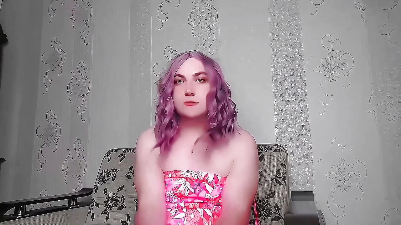Razigrana sissy sjedi bočno na velikoj pahuljastoj stolici