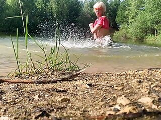 Câmera lenta pulando no lago com roupas. molhada e divertida