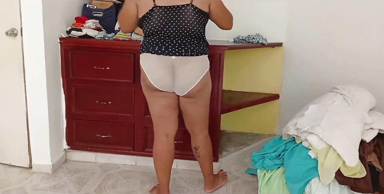 Mollig meisje dat de kamer opruimt en kleren vouwt