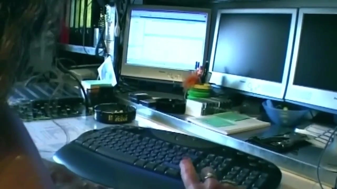 Kıvırcık esmer ofis sandalyesinde sert biniyor