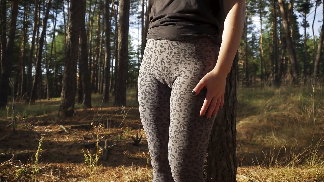 Mädchen neckt draußen ihren großen cameltoe in Leopard leggings