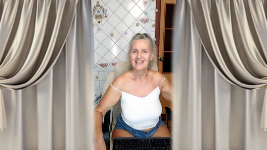 Cheerful housewife Lukerya flirts in the kitchen in tight denim shorts.