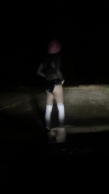 Sissy femboy risicovol buitenshuis 's nachts in glanzende bodysuit en nylon panythose