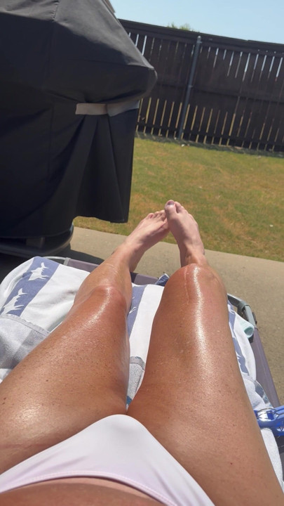 Sissy Cryssi tanning in a bikini with her long sexy legs