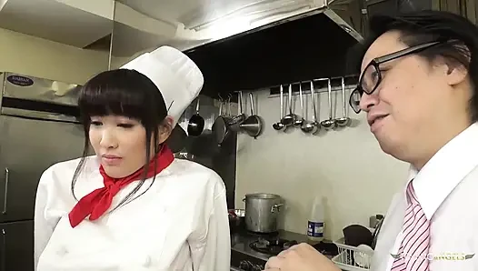 Der Koch und die Restaurantleitung tadeln den asiatischen Koch, indem sie sie anwies sie, dickes gemüse zu drücken