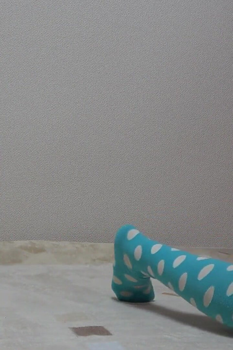 Een Japans meisje dat het appartement van een meisje schoonmaakt in een T-shirt met een beetje borsten, gekleed in een minirok, string en slipje.