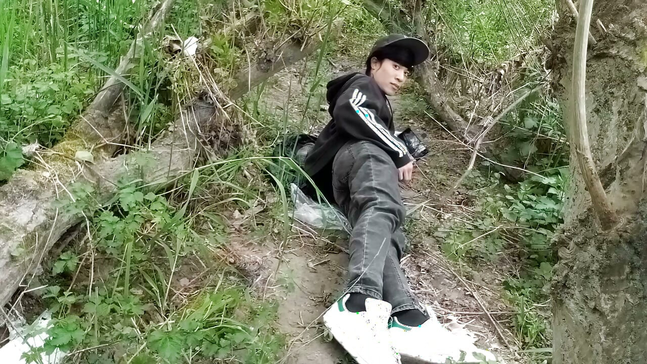 The cute gay twink jerking off his cock, pulled through his fly while outdoors, is Jon Arteen