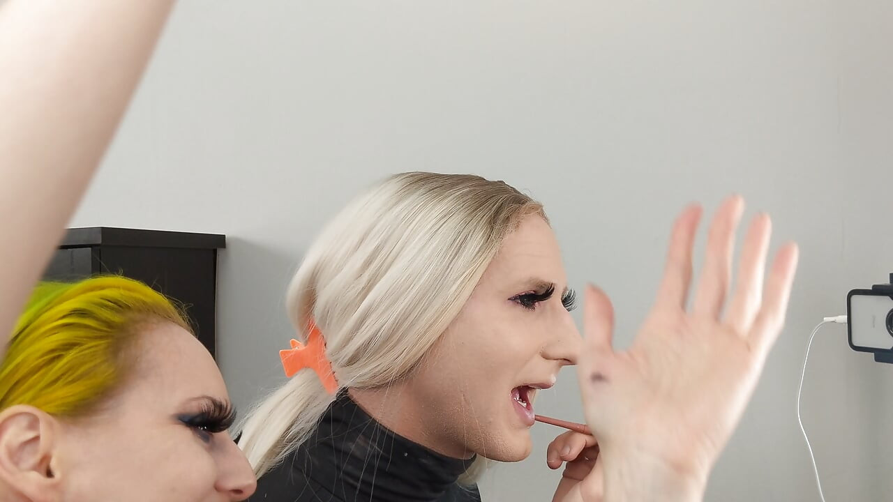 Crossdresser and Woman Putting on Lipliner and Lipstick