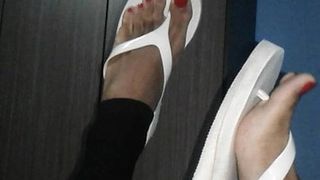 Meus pés sensuais na plataforma de flip-flop