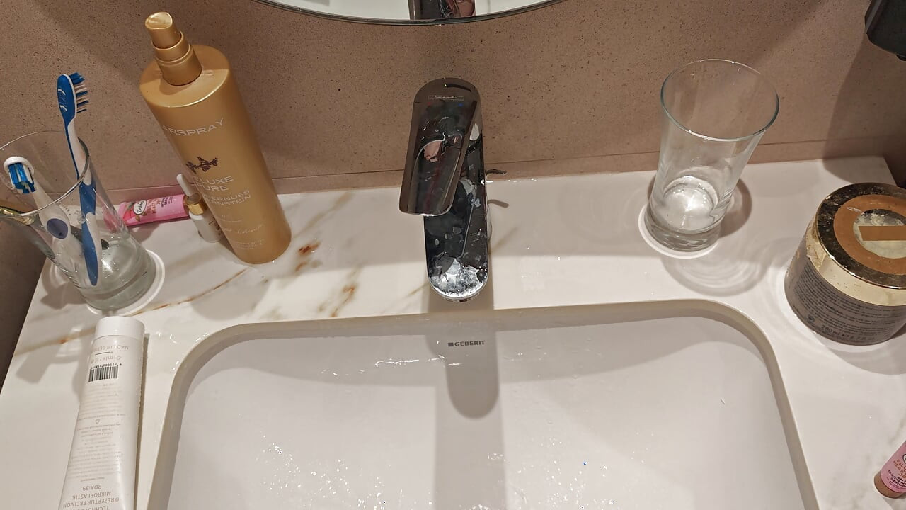 Young man pissing in the sink
