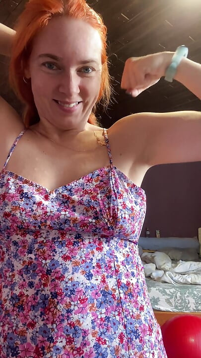 Rödhårig kvinna i vacker klänning som visar hennes muskler och bröst, hur stark är hon och hur hon kan boxas topless