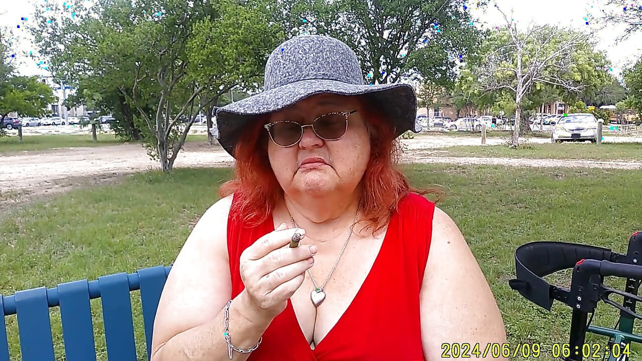 Hemşire Vicki parkta bankta tamamen giyinmiş sigara içiyor