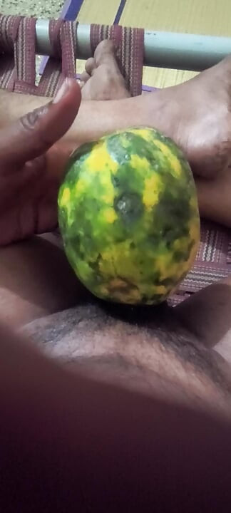 An Indian man enjoys the pleasure of inserting his penis into a papaya fruit
