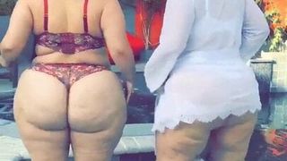 2个性感的胖女人在泳池边跳舞