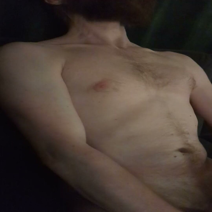 Nude male masturbating on couch