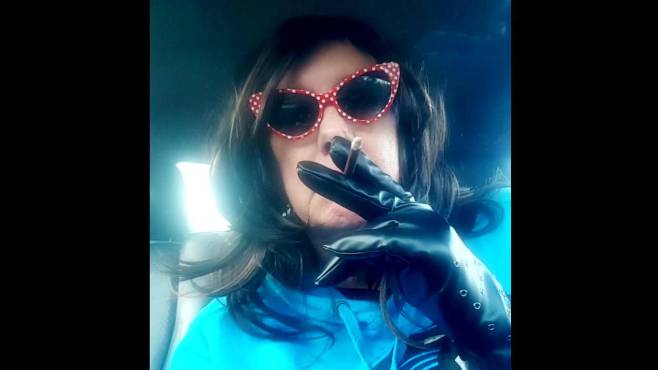 OLGUN ESMER ARABA DERI ELDIVENLER VE GÜNEŞ GÖZLÜĞÜ ILE MORES120 SIGARA IÇIYOR TG CD TS